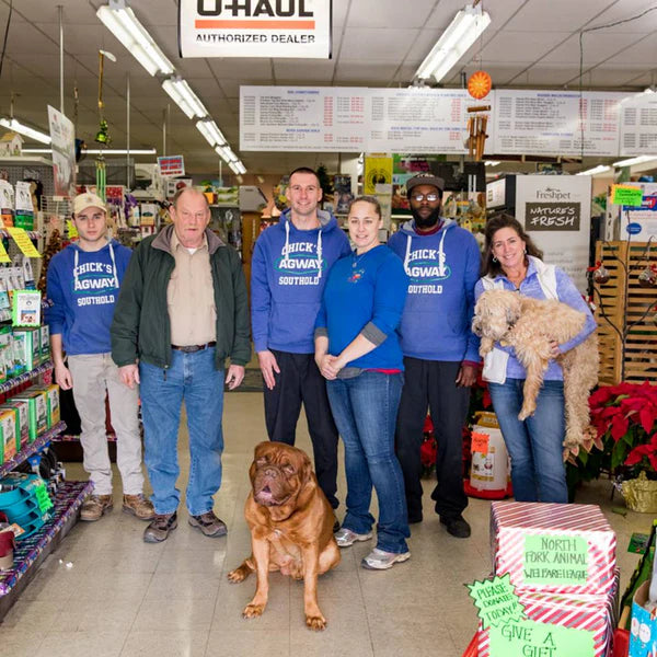 The Chick's Southold Agway team posing for a photo with two dogs.